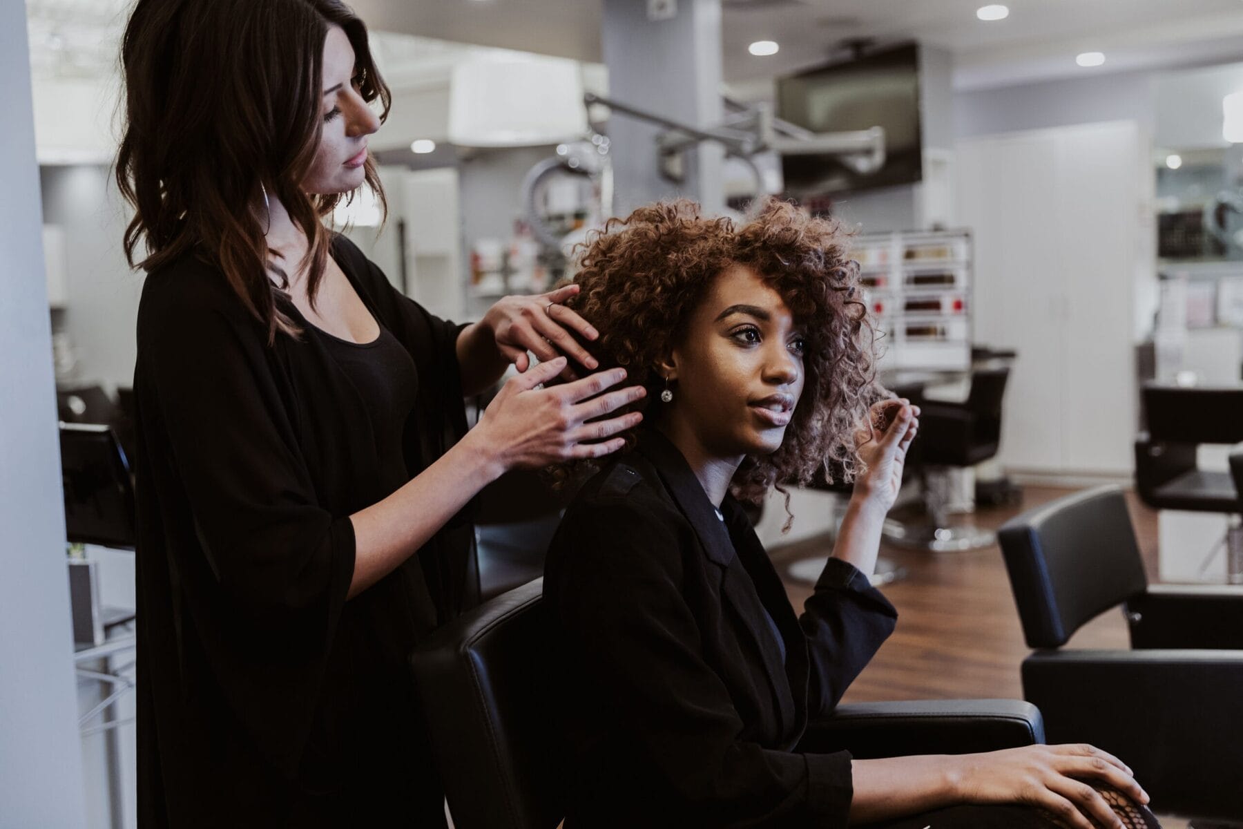Stylist working through a client's curls on the salon floor